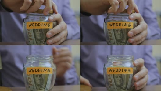 一个白人男人把一个玻璃罐子放在抽屉里，里面装着他的积蓄，为将来的婚礼做准备。高清在线视频素材下载