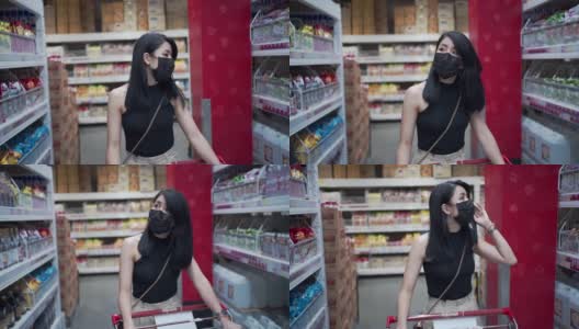 迷人的亚洲女人戴着防护面罩推着购物车在杂货店，货物工厂仓库得到供应，人类消费，covid19新常态，预算生活成本，超市过道行走高清在线视频素材下载