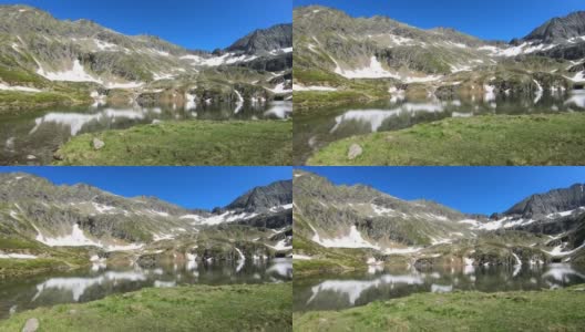这是一个平静的湖，隐藏在奥地利阿尔卑斯山的高处，在Schladming附近。融雪使湖的面积增大了。山坡上有很多雪原。郁郁葱葱的山坡上。早春。宁静高清在线视频素材下载