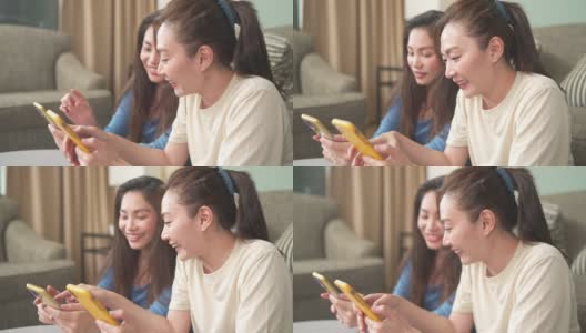 4K亚洲女性朋友一起在客厅用智能手机玩游戏高清在线视频素材下载
