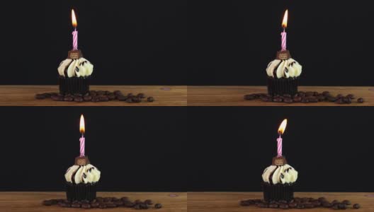 美味的黄油纸杯蛋糕，蜡烛和咖啡豆在木桌上移动高清在线视频素材下载