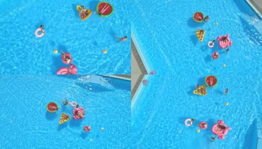 空中俯仰:健康的人们在游泳池里的充气浮子上打水仗高清在线视频素材下载