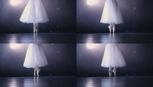 白色芭蕾舞演员的腿后面是一个黑色的舞台。高清在线视频素材下载