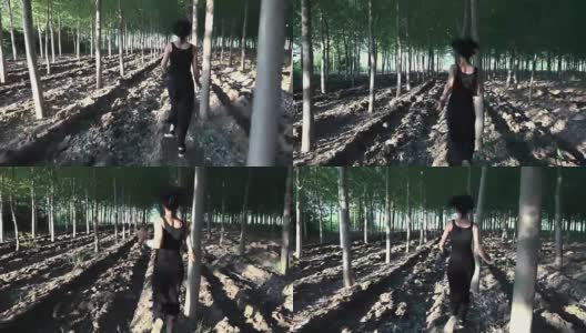 追逐着一个在树林中奔跑的受惊的女人。女孩试图逃脱在森林里追赶她的人高清在线视频素材下载