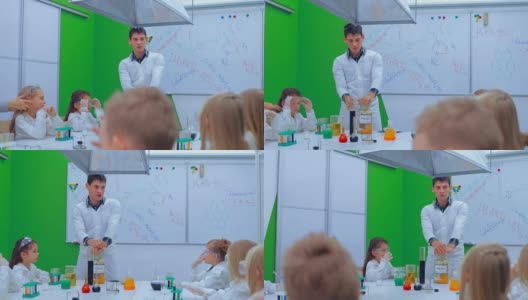 年轻的男孩和女孩们正在做化学实验。老师和小朋友在上化学课高清在线视频素材下载