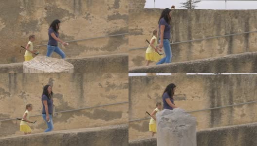 母女俩走上突尼斯迦太基废墟上的古老楼梯高清在线视频素材下载