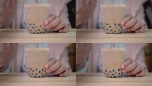 用塑料吸管在桌上搅拌台湾奶茶。高清在线视频素材下载