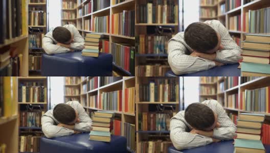 一个高中生在图书馆看书时睡着了。图书馆的概念高清在线视频素材下载