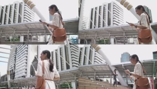 亚洲女商人在步行上班时使用智能手机高清在线视频素材下载