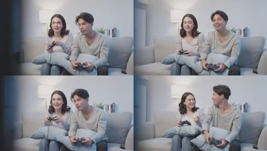 亚洲年轻男女夫妇喜欢在家里一起玩游戏。漂亮有趣的男女朋友感觉开心地坐在客厅的沙发上，花时间一起在家里玩操纵杆游戏。高清在线视频素材下载