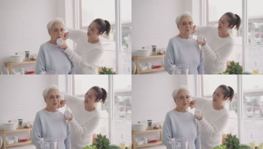 中间的女儿想要亚洲的老妈妈每次都是一个漂亮的女人，所以她在厨房精心打扮自己，准备水果，享受周末的活动，正面的视角，老年的生活方式高清在线视频素材下载
