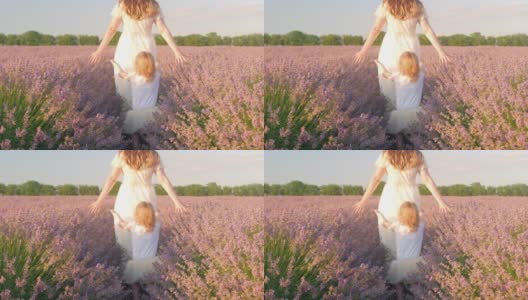 日落时分，母女俩走过一片薰衣草田。热爱自然，香薰，香薰油。自由，幸福，微笑，家人在一起。美丽的花朵。户外生活方式高清在线视频素材下载