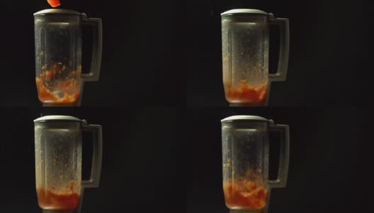 在黑色背景下用慢动作在搅拌机里切番茄高清在线视频素材下载