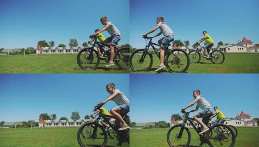 两个朋友一起骑自行车在绿色的草地上高清在线视频素材下载