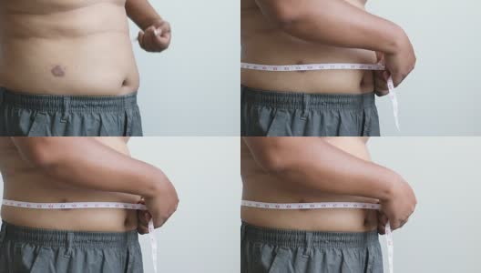 特写镜头，一个胖子用卷尺绕着自己的腰围高清在线视频素材下载