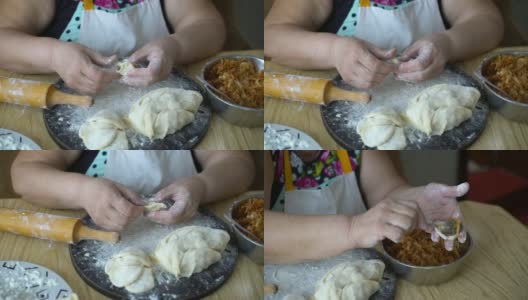 一位年长的妇女正在用烤卷心菜包饺子，乌克兰方式高清在线视频素材下载