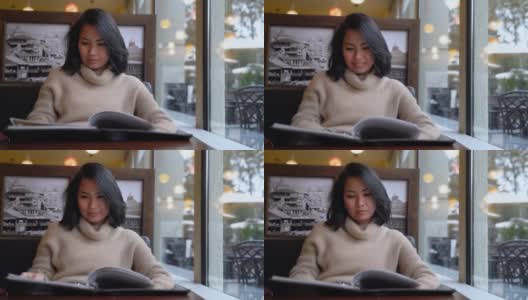 一名亚洲女子在餐馆点餐，从菜单上结账高清在线视频素材下载