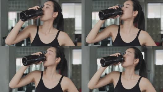 亚洲美女在健身房喝水的肖像。高清在线视频素材下载