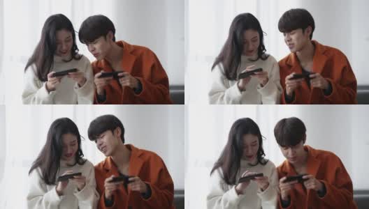 年轻的亚洲夫妇在玩手机高清在线视频素材下载