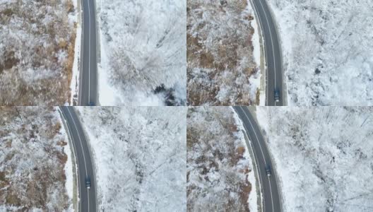 鸟瞰图的冬季道路与汽车和积雪覆盖的森林高清在线视频素材下载