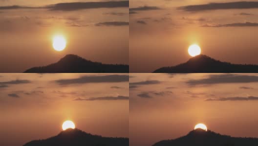 橘黄色的日落，太阳和云朵在山上。高清在线视频素材下载