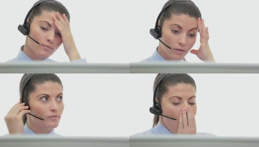昏昏欲睡的年轻女性客户服务在电脑前通过耳机说话。高清在线视频素材下载