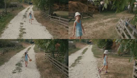 一个小女孩走在尘土飞扬的乡间小路上。真实的人，乡村景色，不寻常的角度。高清在线视频素材下载