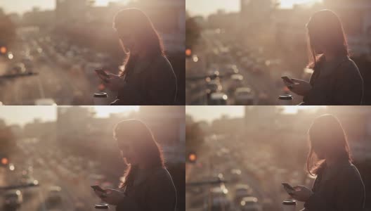 美丽的女孩在一座城市的桥上使用智能手机高清在线视频素材下载