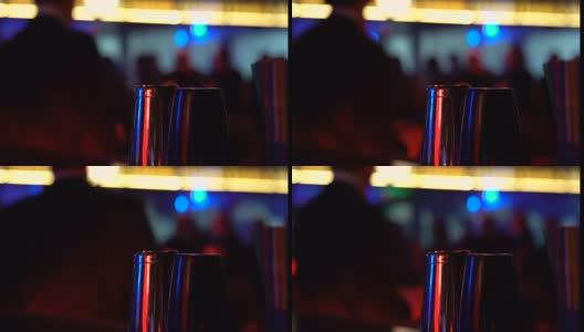 吧台上的摇酒器在跳舞的男人的背景下，夜生活的享受，酒精高清在线视频素材下载