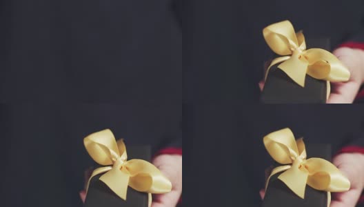 少女展示黑色礼盒与香槟丝带和一个蝴蝶结高清在线视频素材下载
