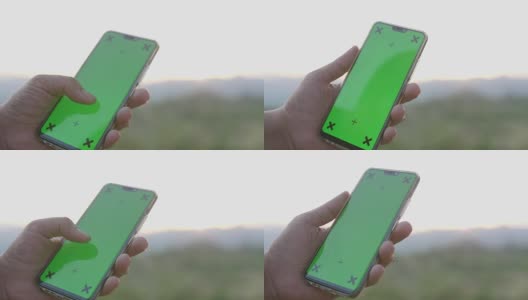 在大自然中使用和清扫绿色屏幕智能手机，色度键高清在线视频素材下载