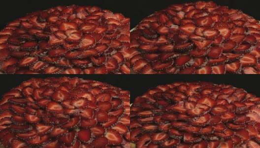 许多红色的草莓被切下，在黑色的背景下缓慢逆时针旋转高清在线视频素材下载
