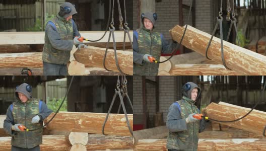 建筑工用吊车吊起木材。一个男人拿着一根木头，把它搬到未来的家高清在线视频素材下载