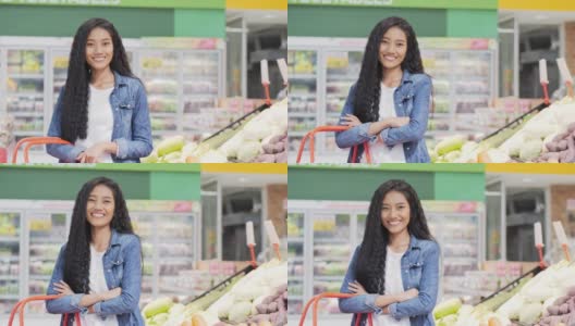 肖像美丽的女人看着相机微笑。年轻的亚洲女人站在超市，心情愉快。高清在线视频素材下载