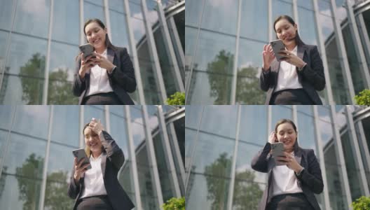 年轻的女商人在城市中行走时使用手机高清在线视频素材下载