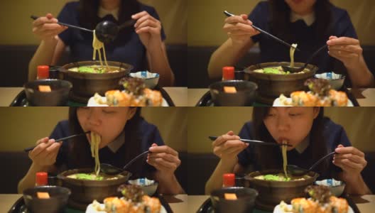 年轻的亚洲女子正在吃一碗日本乌冬高清在线视频素材下载