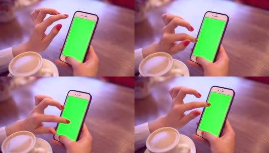 用绿屏智能手机的女人。女人的手在手机上滚动页面的特写视频。色度键。垂直高清在线视频素材下载