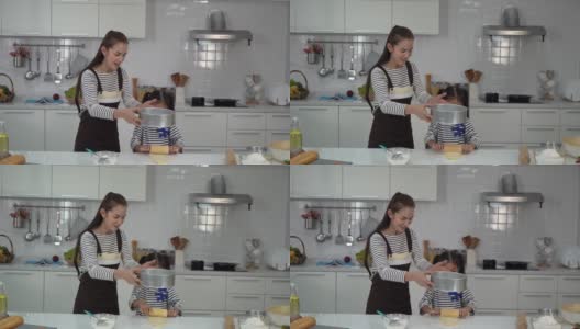 妈妈和孩子一起在家庭厨房做面团和烘焙，为家庭乐趣的概念。高清在线视频素材下载