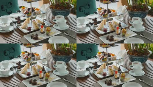 茶具和咖啡与各种糕点在户外咖啡馆。甜蜜的早餐高清在线视频素材下载