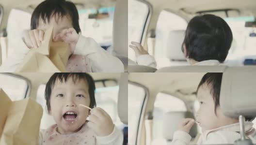 亚洲小男孩和家人在车里吃零食休闲高清在线视频素材下载