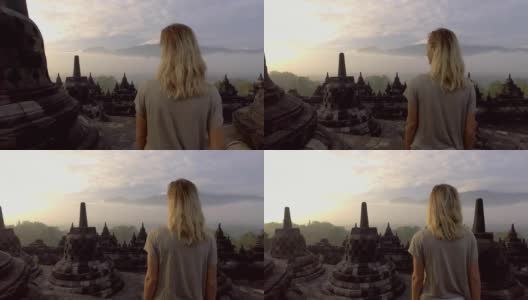 一名年轻女子在婆罗浮屠古代佛教寺庙日出时徘徊的4K视频。人们旅游发现亚洲的概念高清在线视频素材下载