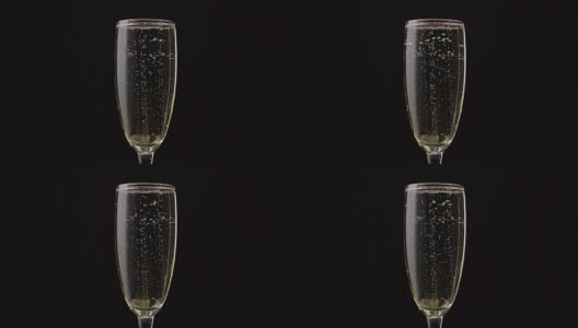 一杯里面有旋转气泡的香槟。黑色背景。近距离高清在线视频素材下载