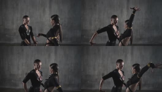 这对年轻的千禧一代舞蹈夫妇身穿黑色礼服，在摄影棚背景下以性感的姿势跳舞。高清在线视频素材下载