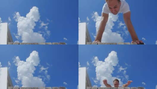 在城市背景下，杂技演员在玻璃人行天桥上表演跑酷技巧的正面特写。一个穿米色裤子和白色t恤的白人。200 FPS慢动作高清在线视频素材下载