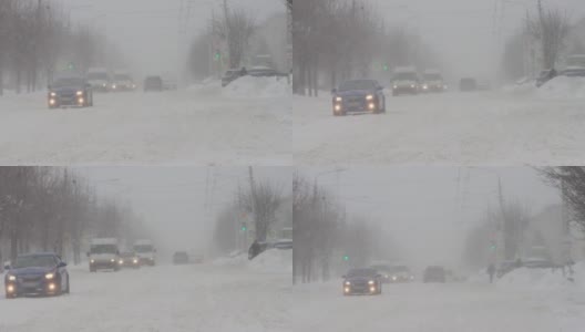 冬天。暴雪暴雪。汽车在城市的雪道上行驶。慢动作降雪。恶劣的天气状况影响了交通。有发生交通事故的危险。十字路口高清在线视频素材下载