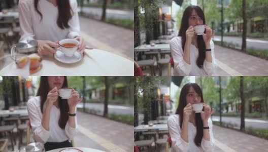 美丽的女人在午餐后在户外咖啡馆喝茶高清在线视频素材下载