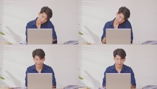 企业家英俊的商业亚洲男人穿着蓝色衬衫在笔记本电脑桌上工作，接听手机与客户交谈，以获得要求或订单微笑和快乐的工作在家里高清在线视频素材下载