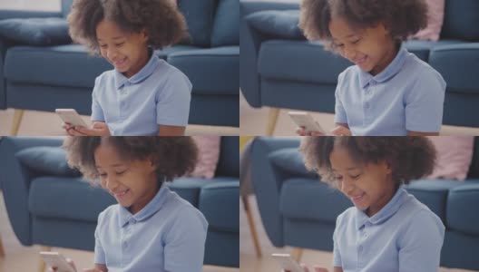 兴奋的黑人女孩在智能手机上玩游戏，使用移动应用程序和微笑高清在线视频素材下载