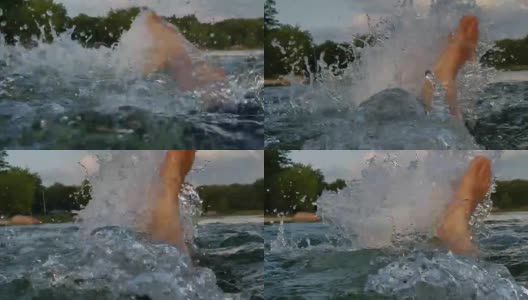 男子在背后游泳，在湖里溅水，旁边是一个十几岁的女孩。高清在线视频素材下载