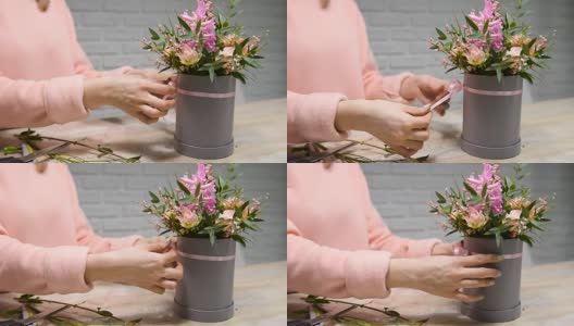 女性双手将花边蝴蝶结插在鲜花盒上高清在线视频素材下载